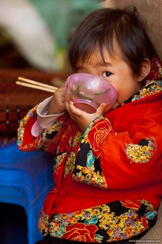 Dubious Deadeye - A young Chinese girl plants her face in her food bowl while keeping a wary eye on the photographer (ARCHIVED PHOTO on the weekends - originally photographed 2007/09/30). - Lijiang, Yunnan, China - Daily Travel Photos - Once Daily Images From Around The World - Travel Photography - Travel Stock Photos Yunnan China, Lijiang, Kids Around The World, Asian Kids, We Are The World, China Travel, Food Bowl, World Cultures, Chinese Culture