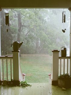 an open porch door with rain falling on it and the words sitting on the porch watching the rain