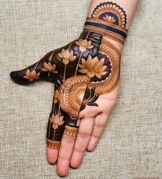 a woman's hand is decorated with hennap and flower designs on it