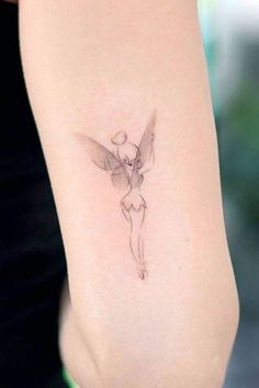 a woman's arm with a small tattoo on the back of her left arm