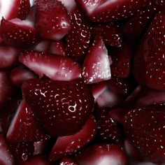 closeup of strawberries with drops of water on them, all in a pile