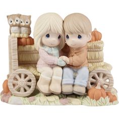 a figurine of two children sitting next to each other on a train with an owl