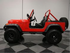 a red jeep is parked on a checkered floor