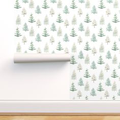 a white wall with trees on it and a roll of paper in front of the wall