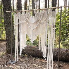 a white macrame hanging from a tree in the woods