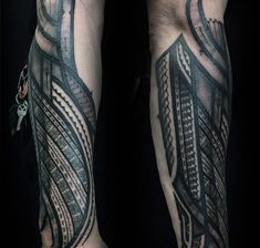 the arm is covered in black and grey ink with an intricate design on it's side