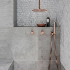 a bathroom with a shower head and two faucets