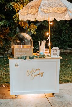 an outdoor ice cream stand with umbrella and lights