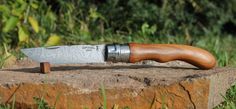 a knife sitting on top of a rock in the grass