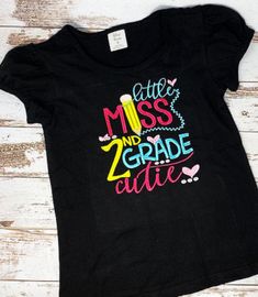 ANY GRADE, Little Miss 2nd Grade Cutie Shirt, Embroidered Back to School Shirt, 2nd Grade School Puffed Sleeve Shirt This design is available in black puffed sleeve shirt or a white puffed sleeve shirt. If you want just a plain shirt please message me as I do have them in stock as well. I use TOP Quality Shirts for embroidery. The Shirts are 100% cotton, they are VERY SOFT!! I have provided a sizing chart! HOW TO PURCHASE: 1. CHOOSE SIZE AND COLOR YOU WOULD NEED 2. CHOOSE GRADE YOU NEED 3. CLICK Black Cotton Tops With Machine Embroidery, Cute Short Sleeve Tops With Machine Embroidery, Embroidered Short Sleeve School Top, Embroidered Short Sleeve Top For School, Girl 2nd Birthday, Puff Sleeve Shirt, Elf Costume, Girls Graphic Tee, Plain Shirt