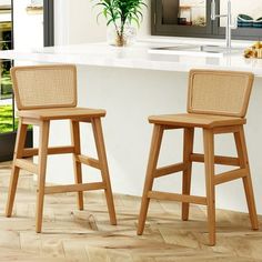 two wooden stools sitting in front of a counter top next to a potted plant