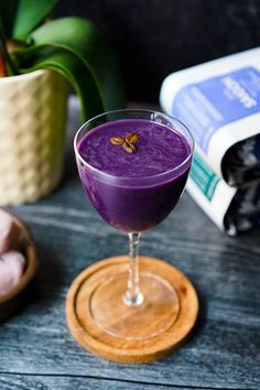 a purple drink sitting on top of a wooden table