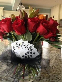 roses in a vase with playing cards on the table