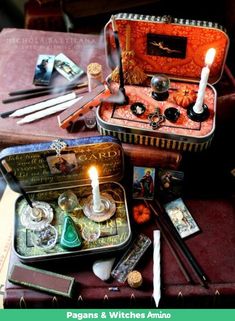 an open suitcase with candles, cards and other items in it sitting on a table