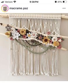 a macrame wall hanging with flowers on it