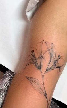 a woman's arm with a flower tattoo on it