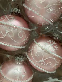 four pink ornaments in plastic wrapped in clear cellophane