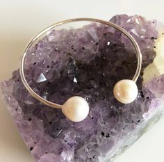 This casually chic cuff is made with fine metal round wire and white fresh water pearls. Bangle is hand- formed, hammered and polished for a stunning texture and shine. It's super fun and versatile to wear and easily adjustable to any wrist size. White fresh water pearls are 9-10mm. As you can see in the photos there are naturally occurring blemishes that give these pearls characters. These are stock photos so please note pearls are vary in shape and color. Each bangle is custom made to order so Elegant White Round Cuff Bracelet, Formal Beaded Pearl Bangle Bracelet, Elegant White Pearl Bangle, Elegant White Cuff Bracelet, White Pearl Bangle As A Gift, Elegant Cuff Bracelet For Bridesmaids, Elegant Pearl Cuff Bracelet For Formal Occasions, Classic White Cuff Bracelet For Wedding, White Cuff Bangle As Gift