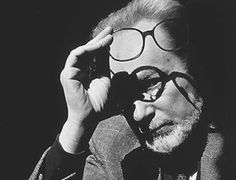 black and white photograph of a man with glasses looking through the rims of his eyeglasses