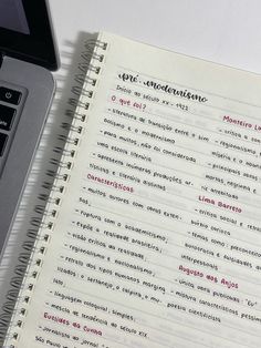 a laptop computer sitting on top of a desk next to a notebook with spanish writing