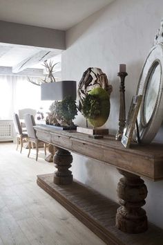 a wooden table topped with a mirror next to a lamp