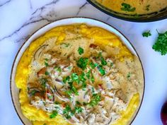 two bowls filled with food on top of a table