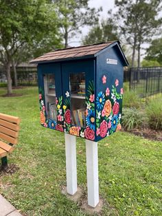 a painted mailbox sitting on top of a wooden bench