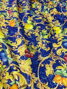 a blue and yellow table cloth with fruit on it