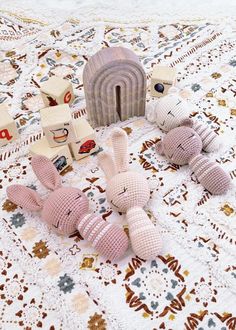 three stuffed animals are laying on a tablecloth with other toys in front of them