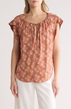 A bandana-inspired floral print adds to the free-spirited feeling of this lightweight top with ruffled sleeves. Split U-neck with ties Short sleeves 100% viscose Dry clean Imported Casual Tie Neck Tops For Summer, Casual Tie Neck Top For Vacation, Summer Printed Tie Neck Tops, Printed Tie Neck Tops For Summer, Summer Floral Print Tie Neck Top, Summer Cotton Tie Neck Top, Casual Boho Print Rayon Tops, Casual Rayon Tops With Boho Print, Casual Tie Neck Blouse