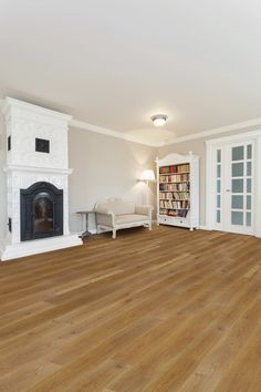 an empty living room with hard wood floors and white bookcases on the wall