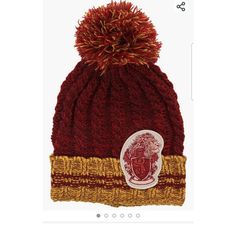 a red and yellow knitted hat with a pom - pom