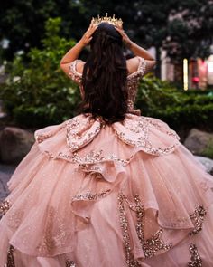 a woman in a pink dress is walking down the street with her hands on her head