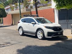 a white honda cr - v parked in front of a building