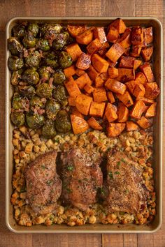 meat, vegetables and potatoes in a baking dish on a wooden table with a spoon