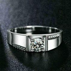 a white gold ring with channeled diamonds on the sides and a center stone in the middle