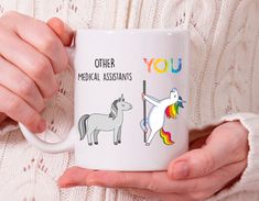 a woman holding a coffee mug with two unicorns on it and the words, you other librarians