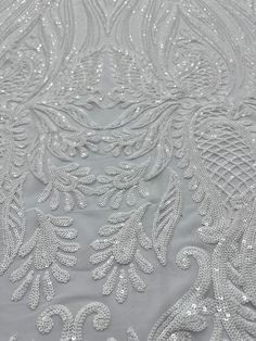 an embroidered fabric with silver sequins on it