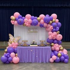 a purple and pink balloon arch with gold accents