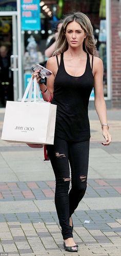 a woman walking down the street carrying shopping bags