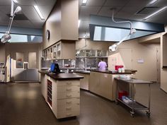 a large kitchen with lots of counter space and lights hanging from the ceiling above it