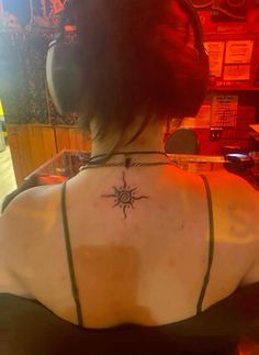 a woman with headphones and a tattoo on her back