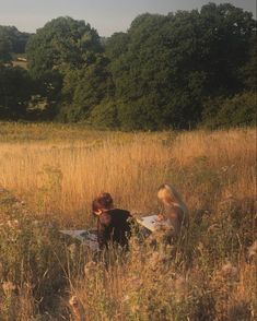 two people are sitting in the tall grass