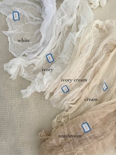 several different types of white and ivory scarves with names on them, labeled in blue