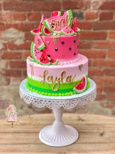 a pink and green cake with watermelon on top