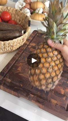 a pineapple sitting on top of a wooden cutting board