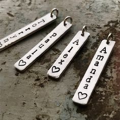 "Personalized name charm with heart. Need to add an extra charm to your necklace? Add on charms are perfect with all of our custom stamped jewelry or to add onto a necklace you already own. 1 1/4\" silver bar charms are handstamped in our signature lowercase font. Length varies slightly, as these are cut to the length of the name provided. Charms are a heavy gauge aluminum, they are super lightweight, won't tarnish and are hypo-allergenic and nickel free. Features a beveled edge and brushed fini Personalized Silver Charms For Everyday, Customizable Silver Pendant Charms, Customizable Silver Charms For Personalized Gift, Silver Nameplate Charm Necklace With Names, Customizable Sterling Silver Nameplate Charm Necklaces, Silver Charm Necklaces With Custom Name For Personalized Gift, Personalized Silver Charms For Mother's Day, Personalized Hand Stamped Charm Necklaces, Sterling Silver Custom Charm Handwriting