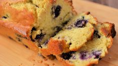 a loaf of blueberry bread sitting on top of a wooden cutting board