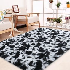 a black and white area rug on the floor in a living room with two chairs