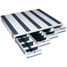 three drawers are open on the side of a white and black striped tablecloth cover